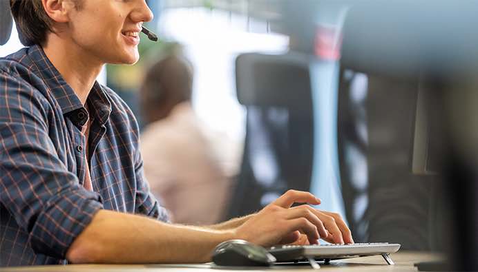 smiling customer service operator typing on keyboard